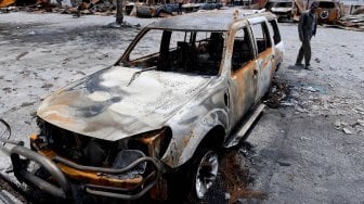 Bangkai mobil yang hangus terbakar di Kantor Bupati Jayawijaya, Wamena, Papua, Rabu (9/10). [ANTARA FOTO/M Risyal Hidayat]