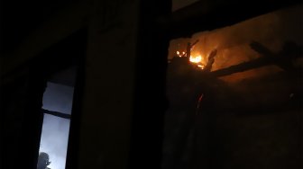 Petugas pemadam kebakaran berusaha memadamkan api yang menghanguskan rumah di kawasan Cawang Atas, Jakarta Timur, Rabu (9/10). [Suara.com/Angga Budhiyanto]