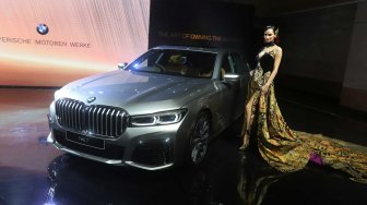 Model berpose di dekat Mobil The New BMW 730Li M Sport dalam peluncuran BMW Seri 7 Long Wheelbase di Jakarta, Kamis (10/10). [Suara.com/Arya Manggala]