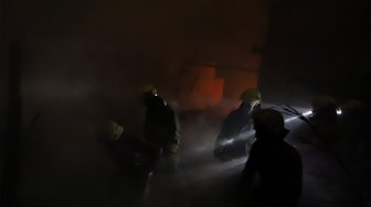 Petugas pemadam kebakaran berusaha memadamkan api yang menghanguskan rumah di kawasan Cawang Atas, Jakarta Timur, Rabu (9/10). [Suara.com/Angga Budhiyanto]
