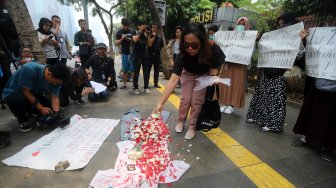 Massa aksi yang tergabung dalam Solidaritas Emak-Emak Indonesia melakukan tabur bunga di depan Polda Metro Jaya, Jakarta, Minggu (13/10). [Suara.com/Arya Manggala]