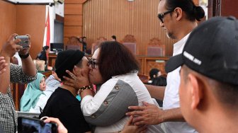 Dua terdakwa kasus dugaan penyalahgunaan narkotika, Tri Retno Prayudati atau Nunung (tengah) dan suaminya July Jan Sambiran mencium anaknya Ratih Sari seusai sidang lanjutan di Pengadilan Negeri Jakarta Selatan, Jakarta, Rabu (16/10). [ANTARA FOTO/Sigid Kurniawan]