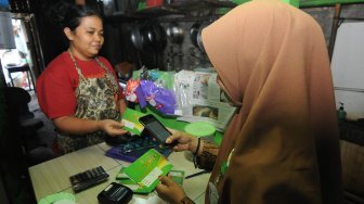 Petugas menggunakan aplikasi elektronik koperasi (e-koperasi) BMT Tumang Mobile saat transaksi dengan anggota koperasi pedagang makanan di Boyolali, Jawa Tengah, Rabu (16/10). [ANTARA FOTO/Aloysius Jarot Nugroho]
