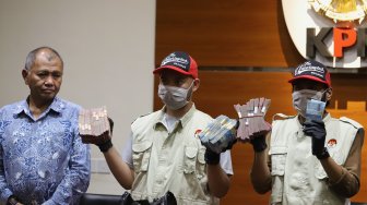 Ketua Komisi Pemberantasan Korupsi (KPK) Agus Rahardjo (kiri) menyaksikan petugas menunjukkan barang bukti operasi tangkap tangan ( OTT) Wali Kota Medan saat konferensi pers di Gedung KPK, Jakarta, Rabu (16/10). (Suara.com/Angga Budhiyanto)  