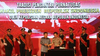 Wakil Presiden Republik Indonesia, Drs. H. Muhammad Jusuf Kalla menerima cenderamata berupa Pedang Pati saat Tradisi Pengantar Purna Tugas Wakil Presiden di STIK-PTIK, Jakarta Selatan, Jumat (18/10). (Suara.com/Angga Budhiyanto) 