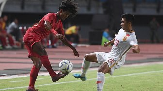 Pesepak bola Indonesia U-19 Amiruddin Bagus Kahfi (kiri) berebut bola dengan pesepak bola China U-19 Aisikaer Aifeierding (kanan) saat laga uji coba di Gelora Bung Tomo, Surabaya, Jawa Timur, Kamis (17/10). [ANTARA FOTO/Zabur Karuru]