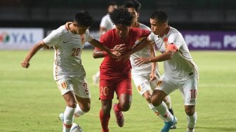 Pesepak bola Indonesia U-19 Amiruddin Bagus Kahfi (tengah) berebut bola dengan pesepak bola China U-19 Mohemaiti Naibijiang (kanan) dan Aisikaer Aifeierding (kiri) saat laga uji coba di Gelora Bung Tomo, Surabaya, Jawa Timur, Kamis (17/10). [ANTARA FOTO/Zabur Karuru]