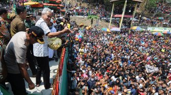 Gubernur Jawa Tengah Ganjar Pranowo (kedua kiri) menyebarkan kue apem saat tradisi Sebar Apem Yaqowiyu di Jatinom, Klaten, Jawa Tengah, Jumat (18/10). [ANTARA FOTO/Aloysius Jarot Nugroho]