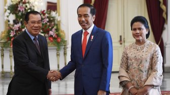 Presiden Joko Widodo (tengah) didampingi Ibu Negara Iriana Joko Widodo (kanan) menerima kunjungan kehormatan Perdana Menteri Kamboja Hun Sen (kiri) di Istana Merdeka, Jakarta, Minggu (20/10). [ANTARA FOTO/Puspa Perwitasari]