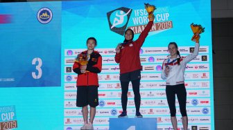 Atlet panjat tebing Indonesia Aries Susanti Rahayu (tengah) melakukan selebrasi usai memecahkan rekor kecepatan dunia saat final Kejuaraan Dunia Panjat Tebing di Xiamen, China, Sabtu (19/10). [ANTARA FOTO/Waspodo]
