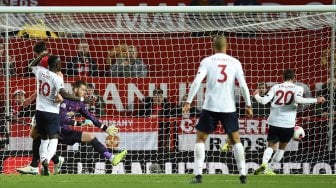 Gelandang Liverpool Adam Lallana (kanan) mencetak gol selama pertandingan sepak bola Liga Inggris antara Manchester United melawan Liverpool di Old Trafford, Manchester, Inggris, Senin (21/10). dini hari WIB. [Oli SCARFF / AFP]