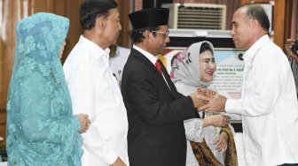 Menko Polhukam Mahfud MD (kedua kanan) didampingi istrinya meneriman ucapan selamat dari pejabat Kemenko Polhukam disaksikan mantan Menko Polhukam Wiranto (kedua kiri) beserta istrinya saat serah terima jabatan di kantor Kemenko Polhukam, Jakarta, Rabu (23/10). [ANTARA FOTO/Hafidz Mubarak]

