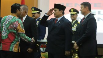 Menteri Pertahanan Prabowo Subianto hormat ke Menkopolhukam Mahfud MD saat acara penyerahan memorandum pelaksana tugas Menteri Pertahanan di Kementerian Pertahanan, Jakarta, Kamis (24/10). [Suara.com/Arya Manggala]