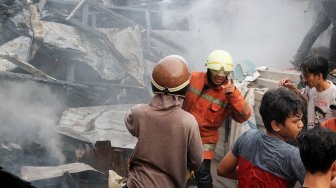 Petugas Pemadam Kebakaran memadamkan rumah yang terbakar di Jalan Anyer, Jakarta, Sabtu (26/10). [Suara.com/Oke Atmaja]