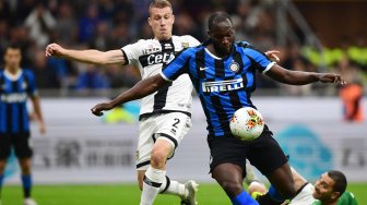 Pemain depan Inter Milan Romelu Lukaku menembak dan menyamakan kedudukan selama pertandingan sepak bola Serie A Italia Inter Milan melawan Parma di Stadion Giuseppe Meazaa, Milan, Italia, Minggu (27/10) dini hari WIB. [Miguel MEDINA / AFP]