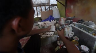 Pekerja menyelesaikan pembuatan plakat wayang dan garuda di Industri Rumahan Pluit, Penjaringan, Jakarta Utara, Rabu (30/10). [Suara.com/Angga Budhiyanto]
