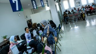 Pegawai melayani warga di kantor Badan Penyelenggara Jaminan Sosial (BPJS) Kesehatan Jakarta Timur, di Jakarta, Rabu (30/10). [ANTARA FOTO/M Risyal Hidayat]