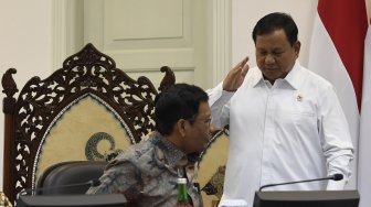 Menko Polhukam Mahfud MD (kiri) berbincang dengan Menteri Pertahanan Prabowo Subianto (kanan) saat akan mengikuti rapat terbatas tentang program dan kegiatan bidang politik, hukum dan keamanan di Kantor Presiden, Jakarta, Kamis (31/10). [ANTARA FOTO/Puspa Perwitasari]