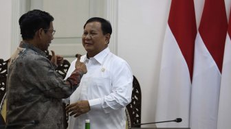 Menko Polhukam Mahfud MD (kiri) berbincang dengan Menteri Pertahanan Prabowo Subianto (kanan) saat akan mengikuti rapat terbatas tentang program dan kegiatan bidang politik, hukum dan keamanan di Kantor Presiden, Jakarta, Kamis (31/10). [ANTARA FOTO/Puspa Perwitasari]