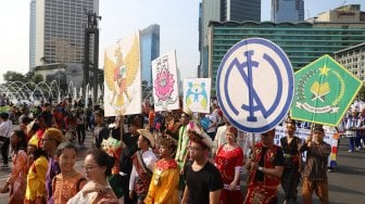 Peserta dari komunitas lintas agama mengikuti gerak jalan di kawasan Hari Bebas Kendaraan Bermotor (HBKB), Jakarta, Minggu (3/11). [Suara.com/Arya Manggala]