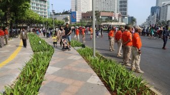 Petugas Satpol PP berjaga di jalur Hari Bebas Kendaraan Bermotor atau Car Free Day, Bundaran HI, Jakarta, Minggu (3/11). [Suara.com/Arya Manggala]