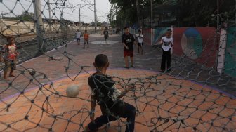 Sejumlah anak bermain sepak bola di pinggir rel kereta api di kawasan Duri, Jakarta Barat, Selasa (5/11).  [Suara.com/Angga Budhiyanto]
