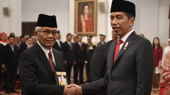 Presiden Joko Widodo (kanan) menyerahkan plakat anugerah gelar pahlawan nasional kepada ahli waris tokoh asal Sumatera Barat Ruhana Kudus di Istana Negara, Jakarta, Jumat (8/11). [ANTARA FOTO/Puspa Perwitasari]