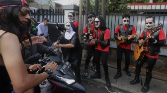 Grup musik Kuburan Band saat ngamen di Jalan Sisingamangaraja, Jakarta Selatan, Kamis (7/11). [Suara.com/Angga Budhiyanto]