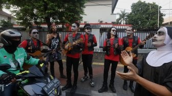 Grup musik Kuburan Band saat ngamen di Jalan Sisingamangaraja, Jakarta Selatan, Kamis (7/11). [Suara.com/Angga Budhiyanto]