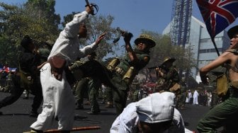 Peserta parade menampilkan aksi teatrikal pertempuran pejuang Indonesia melawan pasukan Inggris saat Parade Surabaya Juang di Jalan Tunjungan, Surabaya, Jawa Timur, Sabtu (9/11). [ANTARA FOTO/Zabur Karuru]