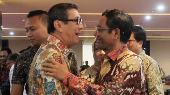 Menteri Hukum dan Hak Asasi Manusia Yasonna Laoly memeluk Menkopolhukam Mahfud MD saat menghadiri acara syukuran di Kementrian Hukum dan Ham, Jakarta, Minggu (10/11). [Suara.com/Oke Atmaja]