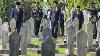 Presiden Joko Widodo (tengah) bersama Wakil Presiden Ma'ruf Amin (kedua kanan) dan Menteri Sosial Juliari Batubara (kiri) berjalan bersama saat akan melakukan tabur bunga usai Upacara Ziarah Nasional di Taman Makam Pahlawan Nasional Utama Kalibata, Jakarta, Minggu (10/11). [ANTARA FOTO/Galih Pradipta]