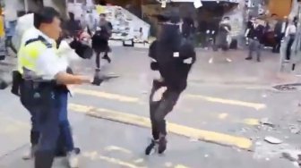 Polisi menembak seorang demonstran prodemokrasi saat terjadi protes di Distrik Sai Wan Ho, Hong Kong, Senin (11/11). [LAURENT FIEVET/CUPID NEWS/AFP]