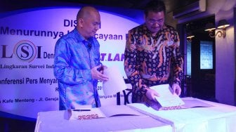 Pengurus Lembaga Afiliasi Penelitian Indonesia - Institut Teknologi Bandung (LAPI ITB) Donald C Lantu (kiri) dan Denny JA berfoto melakukan penandatanganan kerja sama kedua lembaga itu di Jakarta, Rabu (13/11). [Suara.com/Oke Atmaja]