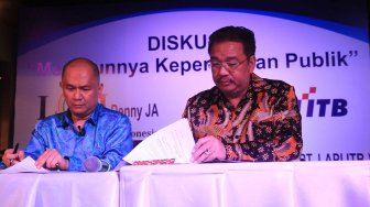 Pengurus Lembaga Afiliasi Penelitian Indonesia - Institut Teknologi Bandung (LAPI ITB) Donald C Lantu (kiri) dan Denny JA berfoto melakukan penandatanganan kerja sama kedua lembaga itu di Jakarta, Rabu (13/11). [Suara.com/Oke Atmaja]