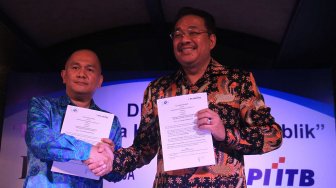 Pengurus Lembaga Afiliasi Penelitian Indonesia - Institut Teknologi Bandung (LAPI ITB) Donald C Lantu (kiri) dan Denny JA berfoto melakukan penandatanganan kerja sama kedua lembaga itu di Jakarta, Rabu (13/11). [Suara.com/Oke Atmaja]