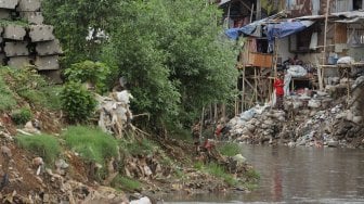 Warga beraktivitas di bantaran Sungai Ciliwung, Kampung Tanah Rendah, Jakarta, Kamis (14/11). [Suara.com/Angga Budhiyanto]