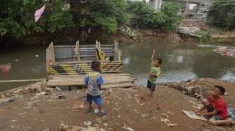 Warga beraktivitas di bantaran Sungai Ciliwung, Kampung Tanah Rendah, Jakarta, Kamis (14/11). [Suara.com/Angga Budhiyanto]