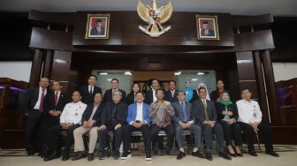 Menko Polhukam Mahfud MD (tengah) didampingi Ketua Dewan Pembina Perhimpunan Advokat Indonesia Otto Hasibuan (ketiga kiri) berfoto bersama usai melakukan audiensi di Gedung Kemenko Polhukam, Jakarta, Kamis (14/11). [Suara.com/Angga Budhiyanto]