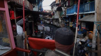 Warga beraktivitas di bantaran Kali Krukut, Kebon Melati, Jakarta, Jumat (15/11). [Suara.com/Angga Budhiyanto]