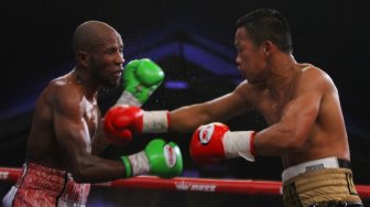 Petinju Daud Yordan (kanan) memukul petinju Afrika Selatan Michael Mokoena (kiri) dalam pertandingan perebutan gelar juara dunia tinju kelas ringan super 63,50 kilogram versi International Boxing Association (IBA) dan World Boxing Organization (WBO) di Batu, Jawa Timur, Minggu (17/11). [ANTARA FOTO/Ari Bowo Sucipto]