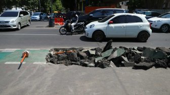 Pengguna jalan melintas di samping jalur sepeda yang dibongkar di kawasan Cikini, Jakarta, Selasa (19/11). [Suara.com/Arya Manggala]