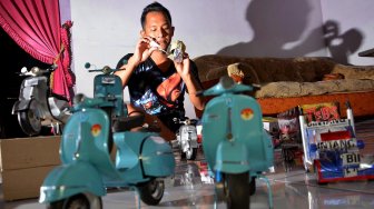 Fatkhurrohman (24) menyelesaikan pembuatan kerajinan miniatur motor vespa serta truk dari kaleng minuman bekas di Desa Ngumpul, Kecamatan Jogoroto, Jombang, Jawa Timur, Selasa (19/11). [ANTARA FOTO/Syaiful Arif]