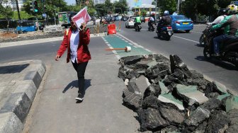 Pengguna jalan melintas di samping jalur sepeda yang dibongkar di kawasan Cikini, Jakarta, Selasa (19/11). [Suara.com/Arya Manggala]