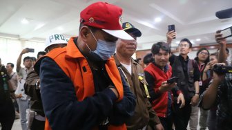 Buronan koruptor Atto Sakmiwata Sampetoding dihadirkan petugas saat konferensi pers pengamanan buronan pelaku kejahatan di Gedung Kejaksaan Agung, Jakarta, Kamis (21/11). [Suara.com/Arya Manggala]
