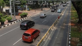 Sejumlah kendaraan melintas di bawah papan informasi Electronic Road Pricing (ERP) di Jalan Medan Merdeka Barat, Jakarta, Selasa (26/11). [Suara.com/Angga Budhiyanto]