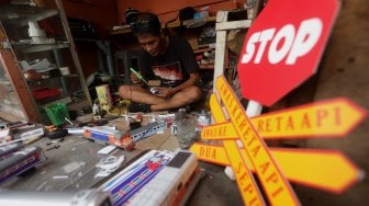 Iskandar (52) menyelesaikan pembuatan miniatur kereta api di kawasan Manggarai, Jakarta, Rabu (27/11).[Suara.com/Angga Budhiyanto]