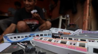 Iskandar (52) menyelesaikan pembuatan miniatur kereta api di kawasan Manggarai, Jakarta, Rabu (27/11).[Suara.com/Angga Budhiyanto]