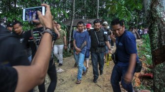 Petugas Direktorat Reserse Narkoba Polda Riau membawa dua orang pelaku pembuat narkoba ketika menggerebek sebuah rumah yang dijadikan tempat pembuatan narkoba jenis pil Happy FIve (H5) di Pekanbaru, Riau, Rabu (27/11). [ANTARA FOTO/Rony Muharrman]