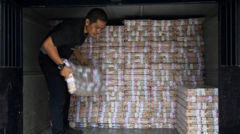 Petugas memindahkan tumpukan uang di Cash Pooling Bank Mandiri, Jakarta, Kamis (28/11). [ANTARA FOTO/Aditya Pradana Putra]